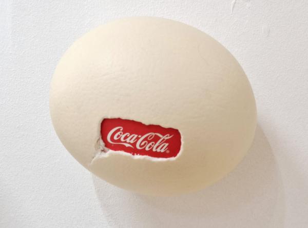 Ostrich egg, CocaCola, 2025, Straußeneierschale, gefundene Verpackung, Mischtechnik